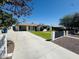 Single-story home with attached carport, large driveway, and mature landscaping at 2450 E Clarendon Ave, Phoenix, AZ 85016