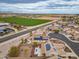 Aerial view of a property featuring solar panels, a pool, desert landscaping, and easy access to nearby community amenities at 25320 W Heathermoor Dr, Buckeye, AZ 85326