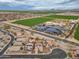 Community aerial shot showcases solar panels, green fields, and well-planned infrastructure in a desert environment at 25320 W Heathermoor Dr, Buckeye, AZ 85326