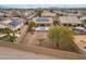 Aerial view of a backyard with a pool, covered patio, desert landscaping, and surrounded by block fencing for privacy at 25320 W Heathermoor Dr, Buckeye, AZ 85326