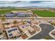 Aerial view of a residential area with solar panels, complemented by open fields and distant mountains at 25320 W Heathermoor Dr, Buckeye, AZ 85326