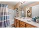 A cozy bathroom featuring a shower-tub combination and a wooden vanity at 25320 W Heathermoor Dr, Buckeye, AZ 85326