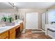 Bathroom featuring a double vanity, mirrored wall, step-in shower and neutral earthy tones at 25320 W Heathermoor Dr, Buckeye, AZ 85326