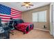 Comfortable bedroom with an American flag on the wall and a ceiling fan at 25320 W Heathermoor Dr, Buckeye, AZ 85326