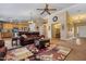 Open-concept living room with a ceiling fan and view into kitchen, creating a seamless flow for modern living at 25320 W Heathermoor Dr, Buckeye, AZ 85326