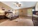 Spacious main bedroom features neutral walls, a ceiling fan, and large wood furniture at 25320 W Heathermoor Dr, Buckeye, AZ 85326