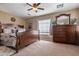 Spacious primary bedroom with a bed, dresser and natural light from a window at 25320 W Heathermoor Dr, Buckeye, AZ 85326