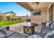 Relaxing covered patio features comfortable seating, ceiling fan, outdoor television, and a view of the landscaped yard at 25583 S 224Th Pl, Queen Creek, AZ 85142