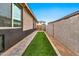 Inviting side yard with artificial turf, a paved walkway and privacy fencing at 25583 S 224Th Pl, Queen Creek, AZ 85142