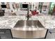 Close up of the stainless steel kitchen sink, faucet and granite countertop at 26716 W Ponderosa Ln, Buckeye, AZ 85396