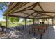 Shaded picnic area featuring multiple picnic tables, benches, and a built-in grill at 26716 W Ponderosa Ln, Buckeye, AZ 85396