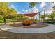 Fun community playground with a sun shade, an orange truck play structure, and a surrounding walkway at 26716 W Ponderosa Ln, Buckeye, AZ 85396