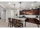 Kitchen with island, dark cabinetry, stainless steel appliances, and attached pantry at 26868 N 104Th Ln, Peoria, AZ 85383