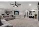 A modern living room with a ceiling fan, carpet flooring and plush seating at 26868 N 104Th Ln, Peoria, AZ 85383