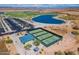 Aerial view featuring well-maintained tennis courts and a nearby pond, offering recreational amenities and scenic views at 26868 N 104Th Ln, Peoria, AZ 85383