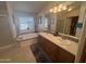 Bright bathroom featuring double sinks, soaking tub, and plenty of natural light at 3301 S Goldfield Rd # 4025, Apache Junction, AZ 85119