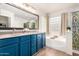 Bright bathroom showcases a dual sink vanity, a soaking tub, and a decorative glass block window for natural light at 3603 S Weaver Cir, Gilbert, AZ 85297