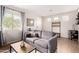 Comfortable living room with a gray sofa, natural light, and wood-style flooring at 3603 S Weaver E Cir, Gilbert, AZ 85297