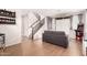 Bright living room with wood floors, gray sofa, stairs, and arcade game at 3603 S Weaver E Cir, Gilbert, AZ 85297