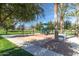 Community playground with swing set, slide, and bench seating amid lush landscaping at 3603 S Weaver E Cir, Gilbert, AZ 85297