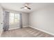 Bedroom featuring neutral tones, a ceiling fan, and a large window for natural light with modern curtains at 36076 N Vidlak Dr, San Tan Valley, AZ 85143