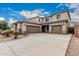 Spacious driveway leading to a three-car garage, surrounded by desert landscaping at 36076 N Vidlak Dr, San Tan Valley, AZ 85143