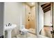 Well-lit bathroom featuring a walk-in shower with stone surround, tiled floors, and pedestal sink at 36430 N 34Th Ave, Phoenix, AZ 85086