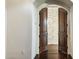 Elegant entryway featuring wood floors, arched doorway, and a glimpse of the bright, stone wall beyond at 36430 N 34Th Ave, Phoenix, AZ 85086