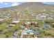 Aerial view shows community and clubhouse with pool surrounded by desert landscape and mountain backdrop at 36600 N Cave Creek Rd # D11, Cave Creek, AZ 85331