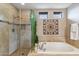 Soaking tub and glass-enclosed shower in bathroom with neutral colored tile and decor at 36600 N Cave Creek Rd # D11, Cave Creek, AZ 85331