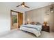 Bedroom featuring a ceiling fan, paneled wall, sliding barn door to bath, and ensuite at 36600 N Cave Creek Rd # D11, Cave Creek, AZ 85331