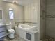 Spa-like bathroom featuring a soaking tub, tiled walls, and modern fixtures at 3707 W Carter Rd, Phoenix, AZ 85041