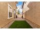 Backyard with artificial grass, paver patio, and white gate at 3819 E Jasper Dr, Gilbert, AZ 85296