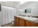 Well-lit bathroom featuring double sinks, a toilet, and a shower with a white curtain at 3819 E Jasper Dr, Gilbert, AZ 85296