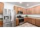 Kitchen featuring stainless steel refrigerator and gas range oven with wood cabinets and tile flooring at 3819 E Jasper Dr, Gilbert, AZ 85296