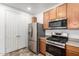 Kitchen featuring stainless steel appliances, wooden cabinets and convenient access to pantry with new flooring at 3819 E Jasper Dr, Gilbert, AZ 85296