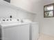 Laundry room with shelving and white washer and dryer units at 3819 E Jasper Dr, Gilbert, AZ 85296