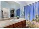 A charming bathroom with a cactus-themed shower curtain and blue walls at 38226 N Kyle St, San Tan Valley, AZ 85140