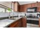 A cozy kitchen with wooden cabinets, stainless steel appliances, and a bright window view at 38226 N Kyle St, San Tan Valley, AZ 85140