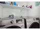 Modern laundry room with shelving and side by side washer and dryer at 38226 N Kyle St, San Tan Valley, AZ 85140