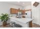 Bright kitchen featuring an island with seating, neutral countertops, ample cabinet space, and modern appliances at 3921 E Runaway Bay Pl, Chandler, AZ 85249