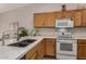 Kitchen featuring an undermount sink, oak cabinets, white countertops, and stainless steel appliances at 3921 E Runaway Bay Pl, Chandler, AZ 85249