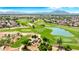 Aerial view of a lush golf course, homes, and a serene water feature in a planned community at 4138 E Indigo St, Gilbert, AZ 85298