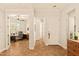 Hallway with tile floors leading to a home office featuring a ceiling fan and shuttered windows at 4138 E Indigo St, Gilbert, AZ 85298