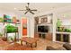 Cozy living room with a ceiling fan, leather furniture, and a built-in entertainment center with shelving at 4138 E Indigo St, Gilbert, AZ 85298