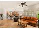 Open-concept living room with tile flooring, ceiling fan, leather furniture, and view of kitchen at 4138 E Indigo St, Gilbert, AZ 85298