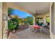 Covered patio with a table and chairs, perfect for outdoor dining and relaxation, overlooking a lush backyard at 4138 E Indigo St, Gilbert, AZ 85298