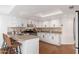 Well-lit kitchen featuring white cabinetry, stainless steel appliances, and breakfast bar at 4151 E Mercer Ln, Phoenix, AZ 85028