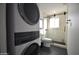 Modern bathroom showcasing a stackable washer/dryer, sleek vanity, glass shower, and black hexagon tile floor at 4206 N 38Th St # 3, Phoenix, AZ 85018