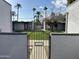 Gated entrance to condo complex with lush green common area and mature palm trees in the Arcadia Courtyards at 4206 N 38Th St # 3, Phoenix, AZ 85018